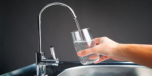 glass of water dispensed from reverse osmosis faucet
